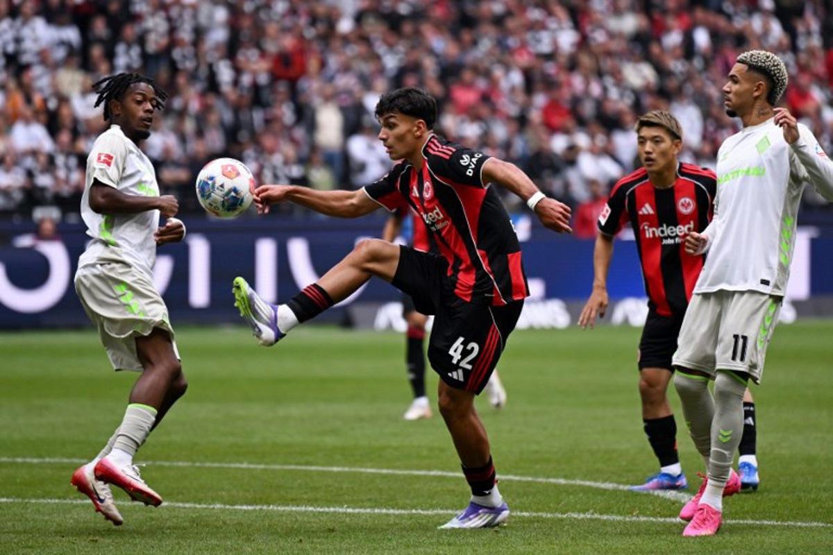 Bremen's Belgian midfielder #07 Samuel Mbangula (L) and Frankfurt's Turkish forward #42 Can Uzun (C) vie for the ball during the German first division Bundesliga football match between Eintracht Frankfurt and Werder Bremen in Frankfurt am Main, western Germany on August 23, 2025.  Kirill KUDRYAVTSEV / AFP