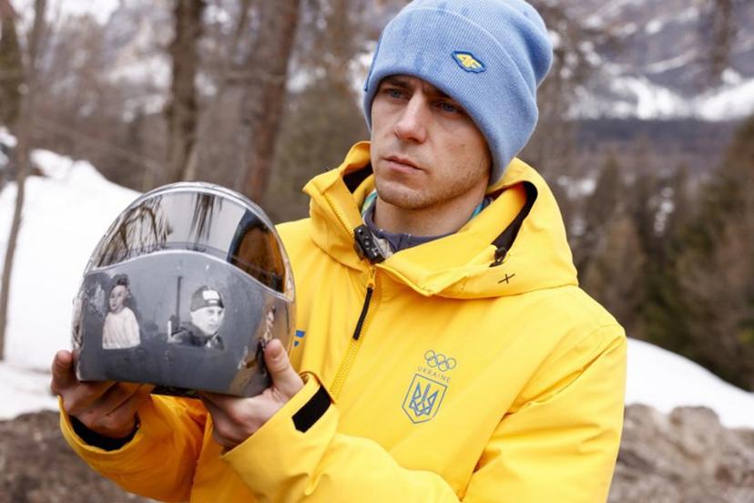 Ukraine's skeleton racer Vladyslav Heraskevych holds his helmet, which depicts victims of his country's war with Russia, in Cortina d'Ampezzo on February 12, 2026. Heraskevych was disqualified from the Winter Olympics on February 12, 2026 after refusing to back down over his banned helmet, which depicts victims of his country's war with Russia. The International Olympic Committee said he had been kicked out of the Milan-Cortina Games "after refusing to adhere to the IOC athlete expression guidelines". Odd ANDERSEN / AFP