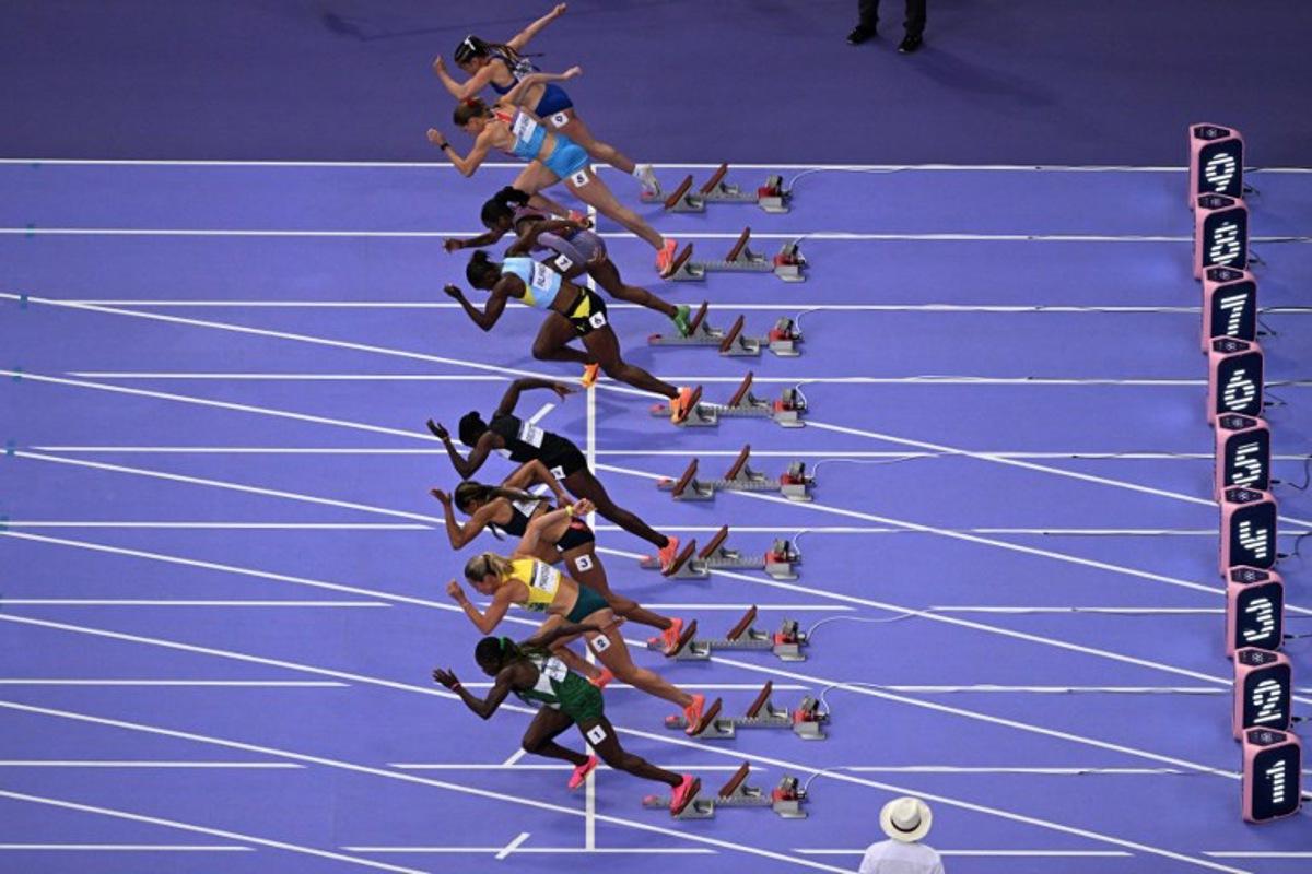 An overview shows Puerto Rico's Gladymar Torres, Luxembourg's Patrizia Van Der Weken, US' Sha'Carri Richardson, St Lucia's Julien Alfred, Gambia's Gina Mariam Bass Bittaye, Britain's Imani Lansiquot, Australia's Bree Masters taking the start and the empty line of Jamaica's Shelly-Ann Fraser-Pryce (C) in the women's 100m semi-final of the athletics event at the Paris 2024 Olympic Games at Stade de France in Saint-Denis, north of Paris, on August 3, 2024.  Antonin THUILLIER / AFP