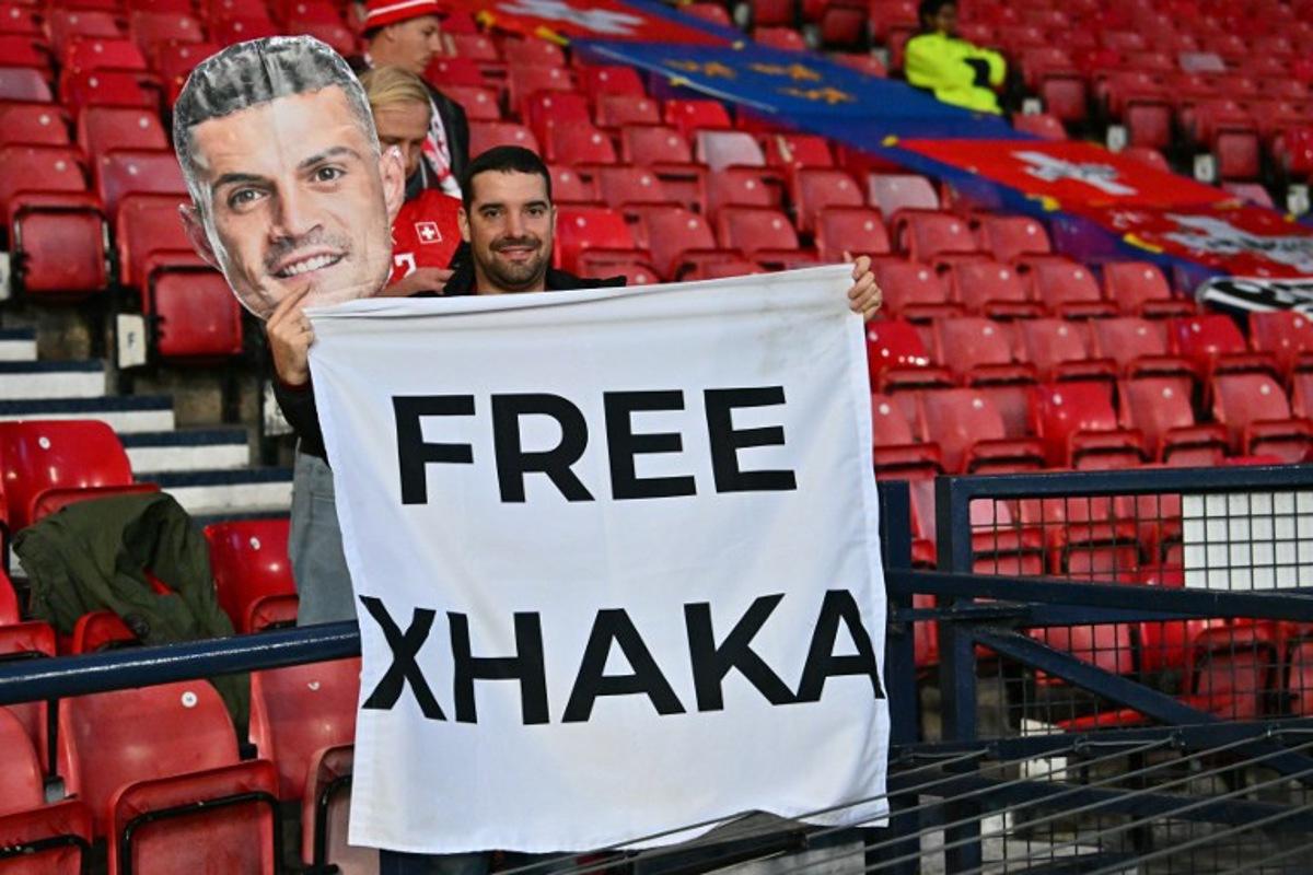 A fan of Switzerland's midfielder Granit Xhaka hlds up a banner in the crowd ahead of the UEFA Nations League, League B, Group 1 match football match between Scotland and Switzerland at Hampden Park in Glasgow, Scotland on September 29, 2026.    ANDY BUCHANAN / AFP