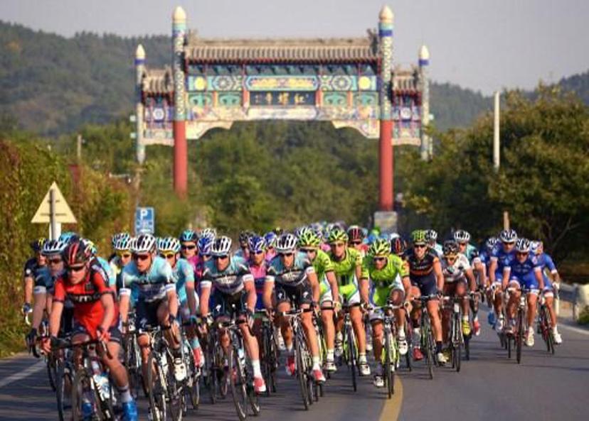 Cyclists ride through a country road during the first stage of the 2013 Tour of Beijing cycling race on October 11, 2013. AFP PHOTO / WANG ZHAO