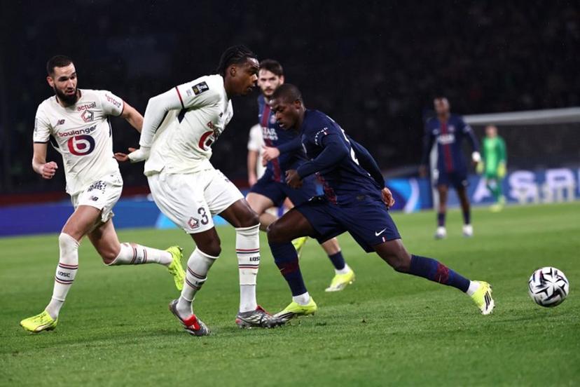 Paris Saint-Germain's Portuguese defender #25 Nuno Mendes (R) and Lille's Belgian defender #03 Nathan Ngoy (2L) fight for the ball during the French L1 football match between Paris Saint-Germain (PSG) and Lille LOSC at the Parc des Princes stadium in Paris on January 16, 2026.  Anne-Christine POUJOULAT / AFP