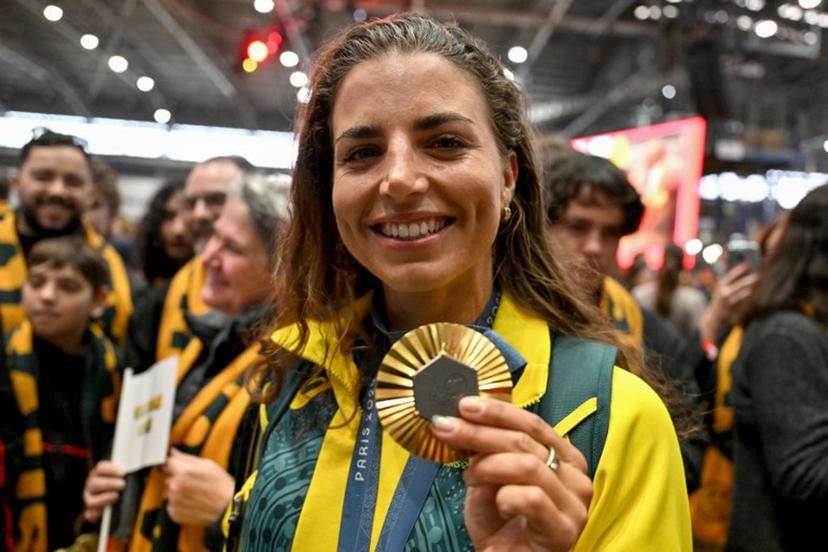 Australia's Jessica Fox, gold medallist in the women's canoe slalom kayak single and canoe single events, displays her medal during an event following her return from the Paris 2024 Olympic Games at the Sydney International Airport on August 14, 2024.   Saeed KHAN / AFP