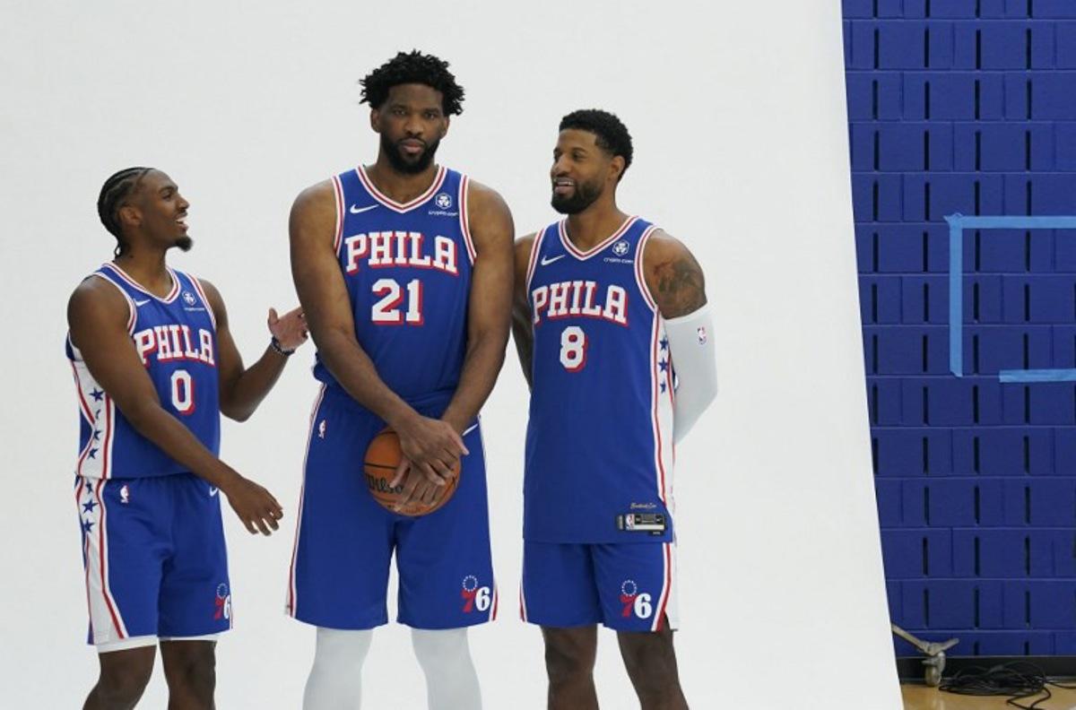 (L-R) Philadelphia 76ers guard Tyrese Maxey, center Joel Embiid and small forward Paul George pose for photos during the 76ers media day ahead of the NBA season at the 76ers Training Complex in Camden, New Jersey, September 30, 2024.  TIMOTHY A. CLARY / AFP