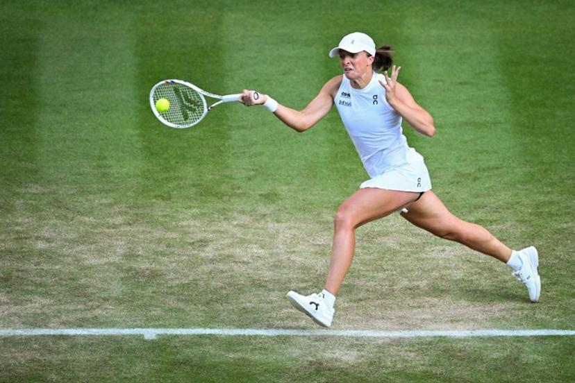 Poland's Iga Swiatek plays a forehand return to Denmark's Clara Tauson during their women's singles fourth round tennis match on the eighth day of the 2025 Wimbledon Championships at The All England Lawn Tennis and Croquet Club in Wimbledon, southwest London, on July 7, 2025.  Kirill KUDRYAVTSEV / AFP