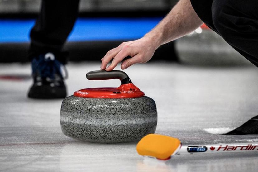 A competitor prepares to curl the stone during the men's bronze medal game of the Beijing 2022 Winter Olympic Games curling competition between Canada and USA at the National Aquatics Centre in Beijing on February 18, 2022.  Jeff PACHOUD / AFP