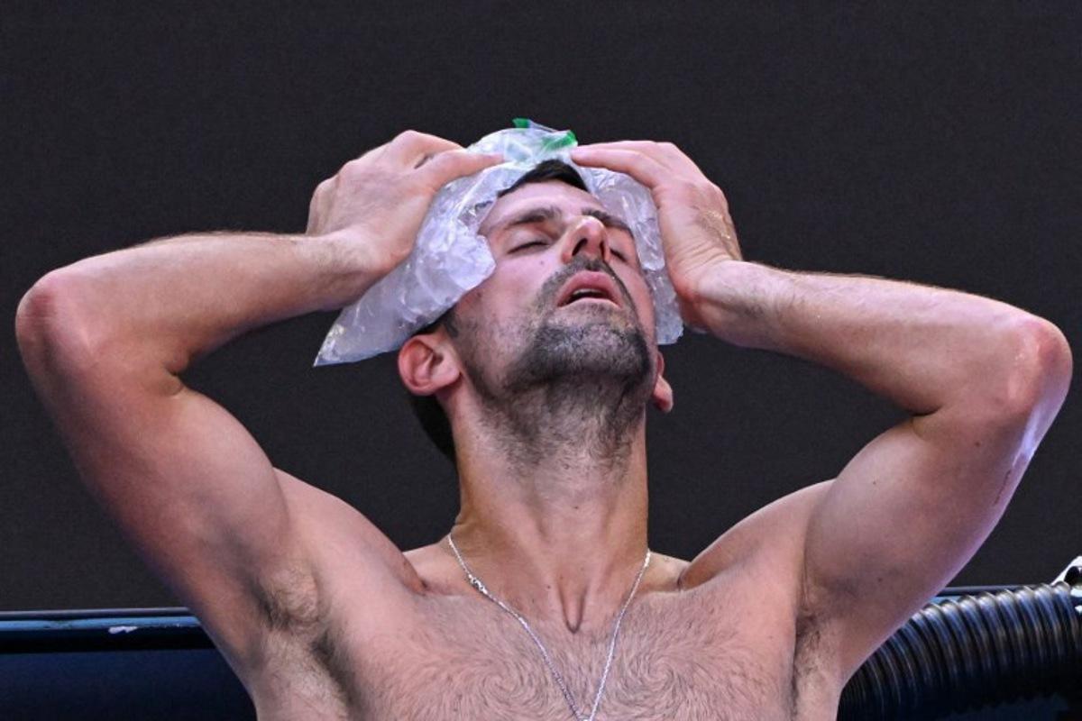 Serbia's Novak Djokovic uses ice packs on his head between the games against USA's Taylor Fritz during their men's singles quarter-final match on day 10 of the Australian Open tennis tournament in Melbourne on January 23, 2024.  WILLIAM WEST / AFP
