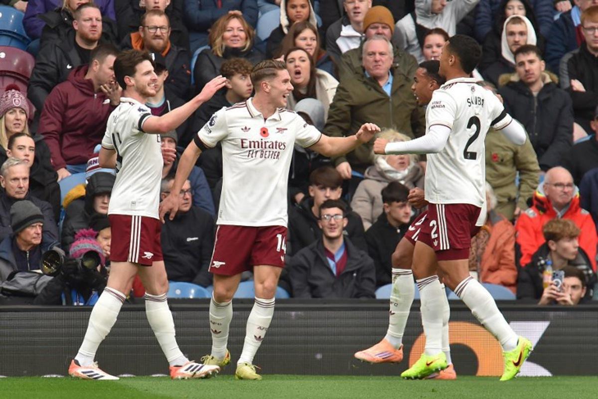 Arsenal's Swedish striker #14 Viktor Gyokeres (C) celebrates with teammates after scoring the opening goal of the English Premier League football match between Burnley and Arsenal at Turf Moor in Burnley, north-west England on November 1, 2025.  PETER POWELL / AFP