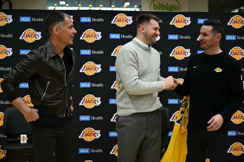 Slovenian basketball player Luka Doncic (C) shakes hands with Los Angeles Lakers head coach JJ Redick (R) as Los Angeles Lakers general manager Rob Pelinka looks on during a press conference introducing Doncic as the newest member of the Los Angeles Lakers, at the UCLA Health Training Center, in El Segundo, California on February 4, 2025. Slovenian star Luka Doncic said February 2, 2025 he thought he'd spend his entire NBA career in Dallas, thanking fans in Texas for making it feel like home a day after the Mavericks abruptly traded him to the Los Angeles Lakers. Patrick T. Fallon / AFP