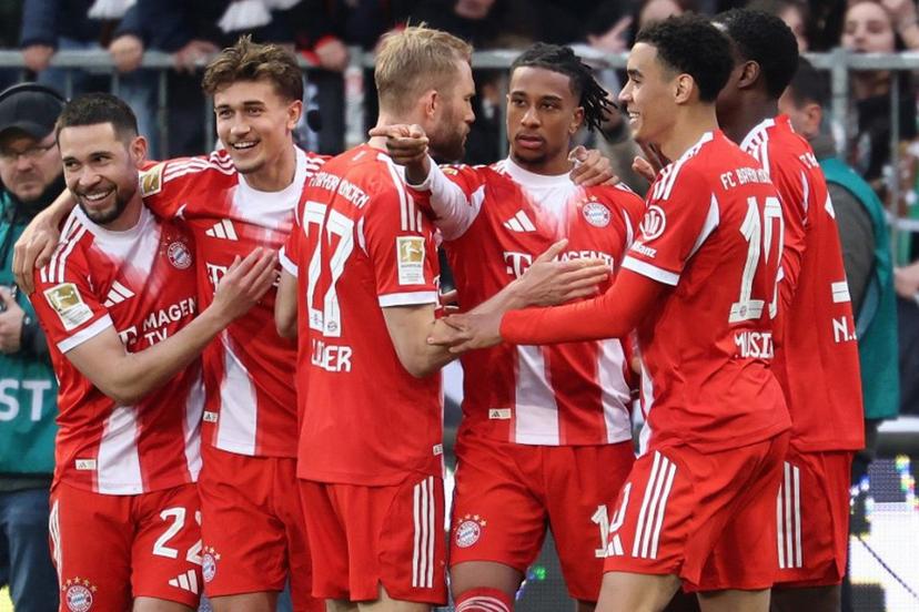Bayern Munich's French midfielder #17 Michael Olise celebrates scoring the 0-3 goal with his teammates during the German first division Bundesliga football match between FC St Pauli and FC Bayern Munich in Hamburg, northern Germany, on April 11, 2026.  Ibo OT / AFP