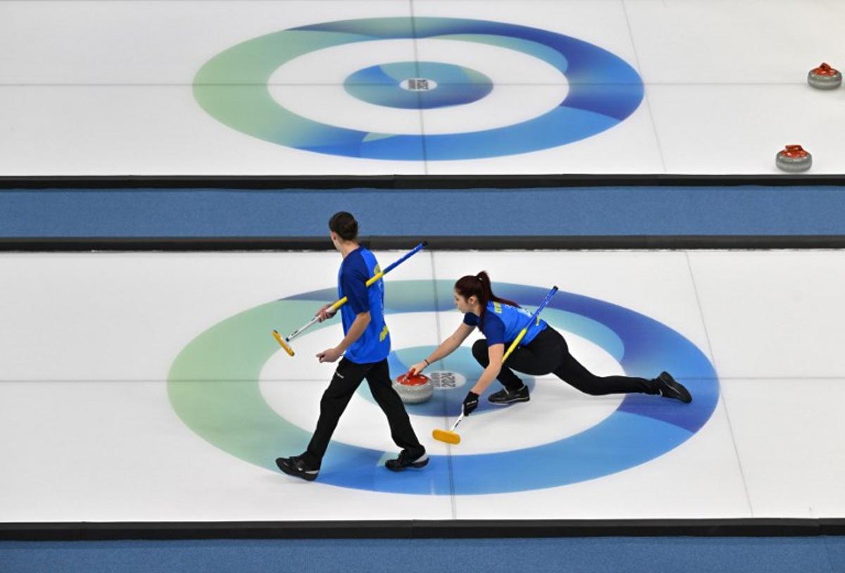 Ukraine's Marharyta Lytvynenko (R) and Artem Shlyk (L) compete against Qatar in the curling mixed doubles round robin session 14 during the Gangwon 2024 Winter Youth Olympic Games at Gangneung Curling Centre in Gangneung on January 31, 2024.  Jung Yeon-je / AFP