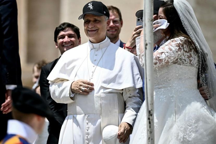 Pope Leo XIV (C) reacts wearing a Chicago White Sox baseball team cap as he meets newly wedded couples during the weekly general audience in St Peter's Square at the Vatican on June 11, 2025.  Filippo MONTEFORTE / AFP