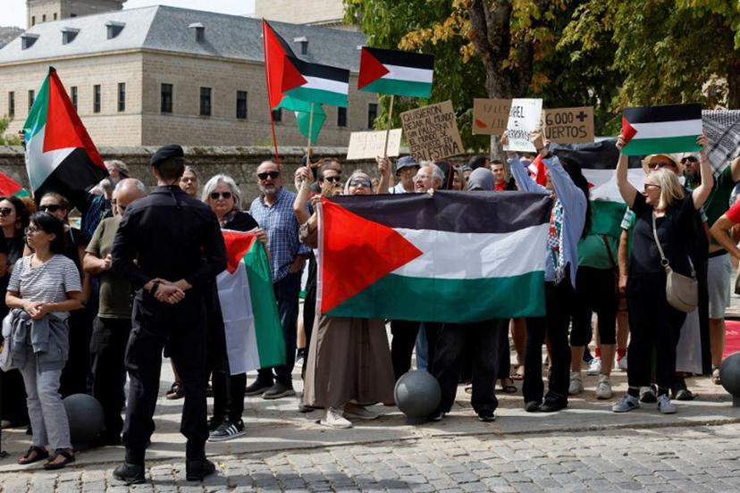 Guardia Civil officers stand as Pro-Palestinians protesters hold Palestinian flags and banners during the 20th stage of the Vuelta a Espana 2025, a 156 km race between Robledo de Chavela and Bola del Mundo, in El Escorial, on September 13, 2025.    Pierre-Philippe MARCOU / AFP