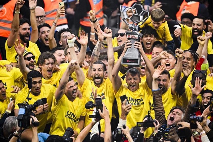 Union's Luxembourgish goalkeeper #49 Anthony Moris (3rd R) raises the trophy as he celebrates with teammates and supporters their Belgian championship title after winning the Belgian Pro League champions' play-off football match (day 10 of 10) between Royale Union Saint-Gilloise and KAA Gent, at the Joseph Marien Stadium in Brussels, on May 25, 2025.  LAURIE DIEFFEMBACQ / AFP