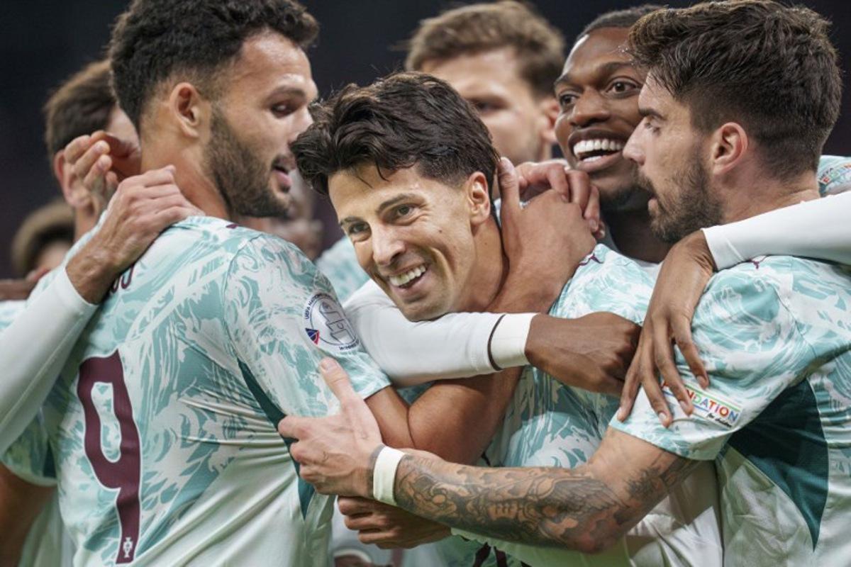Portugal's defender #20 Joao Cancelo (C) celebrates scoring the opening goal with his teammates during the UEFA Nations League Group A4 match between Denmark and Portugal at Parken stadium in Copenhagen on October 1, 2026.   Liselotte Sabroe / Ritzau Scanpix / AFP