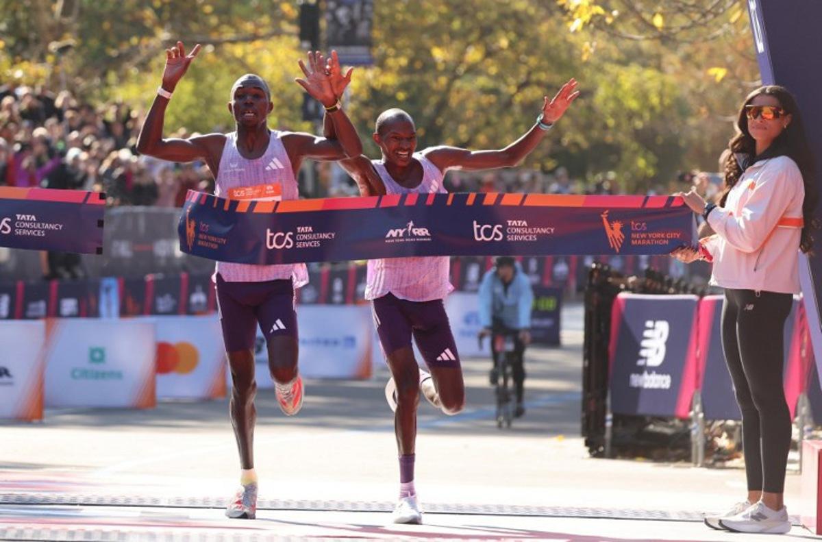 Kenyans Benson Kipruto (L) and Alexander Mutiso celebrate taking first and second place respectively in the New York Marathon in New York on November 2, 2025.  CHARLY TRIBALLEAU / AFP