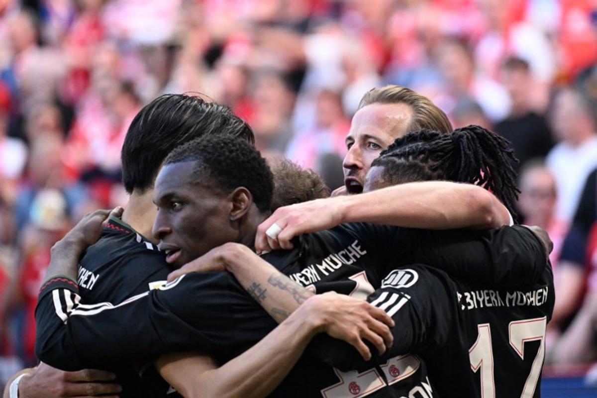Bayern Munich's English forward #09 Harry Kane celebrates with team mates after scoring his team's fourth goal 3:4 during the German first division Bundesliga football match between 1 FSV Mainz 05 and FC Bayern Munich in Mainz, western Germany on April 25, 2026.  Kirill KUDRYAVTSEV / AFP