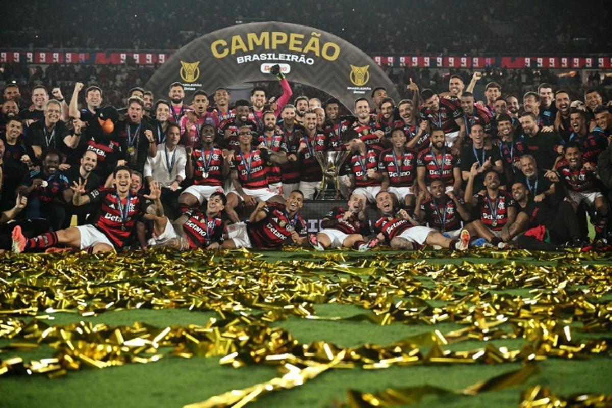 Flamengo's players celebrate with the Brasileirao trophy after winning the Brasileirao Serie A football match between Flamengo and Ceara at Maracana Stadium in Rio de Janeiro, Brazil, on December 3, 2025.  Mauro PIMENTEL / AFP