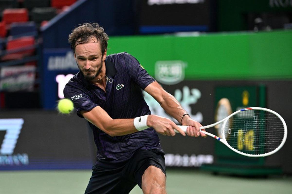 Russia's Daniil Medvedev hits a return to Australia's Alex de Minaur during their men's singles quarter-final match at the Shanghai Masters tennis tournament in Shanghai on October 10, 2025.  Hector RETAMAL / AFP