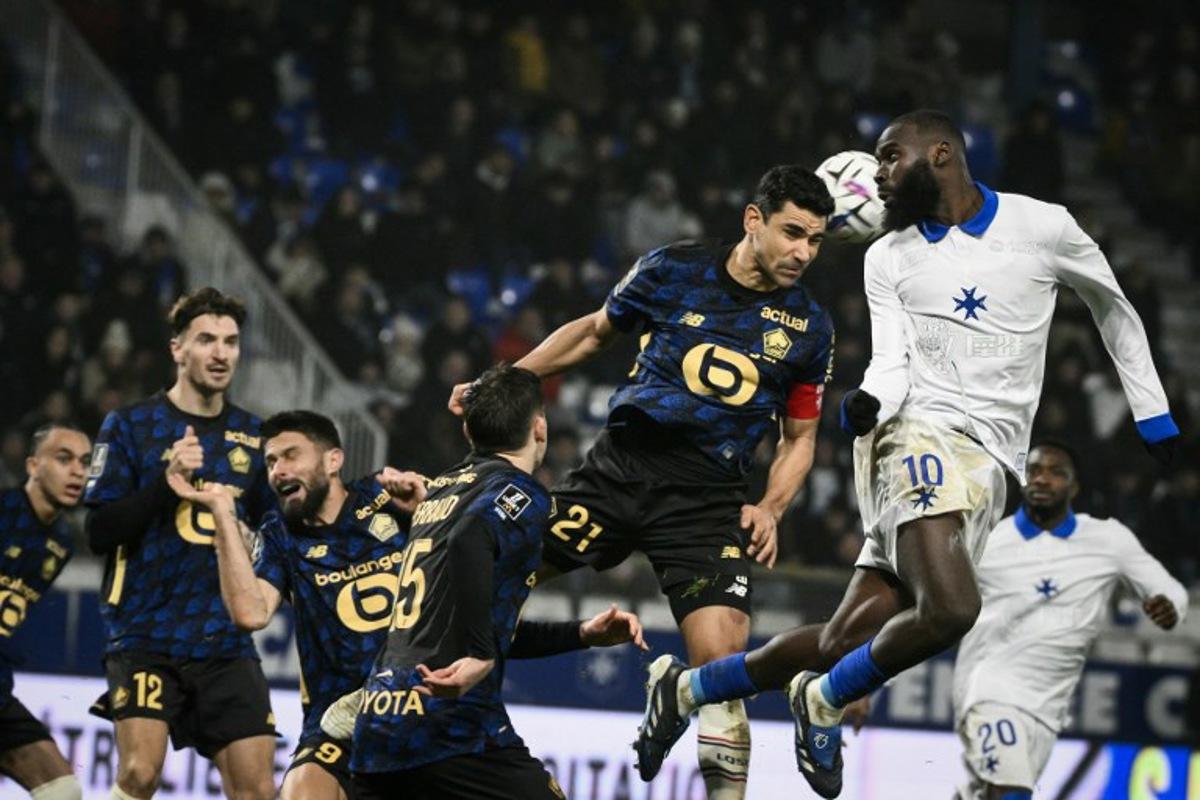 Auxerre's Malian forward #10 Lassine Sinayoko (R) fights for the ball with Lille's French midfielder #21 Benjamin Andre (3R)  during the French L1 football match between AJ Auxerre and Lille LOSC at the Stade de l'Abbe-Deschamps in Auxerre, central France, on December 14, 2025.  ARNAUD FINISTRE / AFP