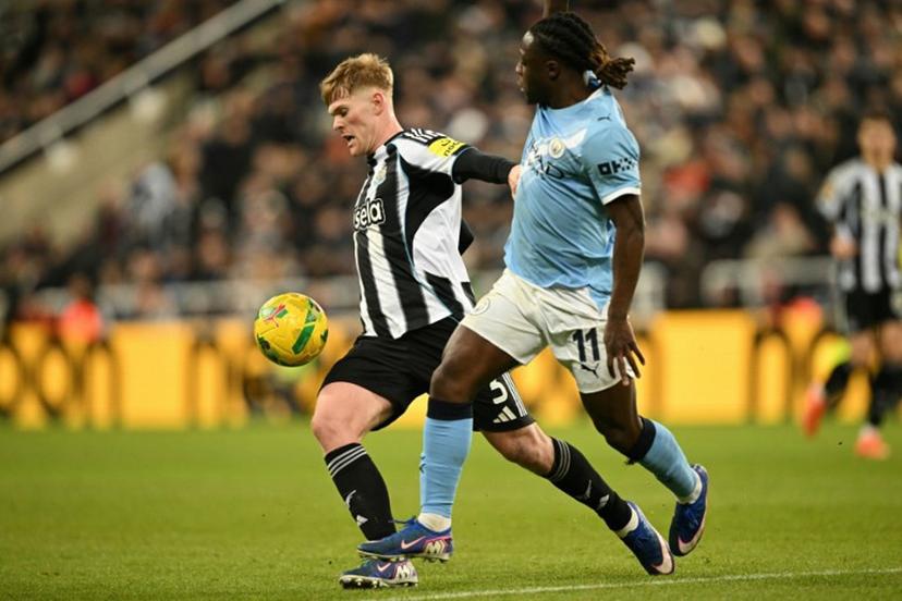 Newcastle United's English midfielder #20 Lewis Hall (L) vies with Manchester City's Belgian midfielder #11 Jeremy Doku (R) during the English League Cup semi-final first leg football match between Newcastle United and Manchester City at St James' Park in Newcastle-upon-Tyne, north east England on January 13, 2026.  Oli SCARFF / AFP