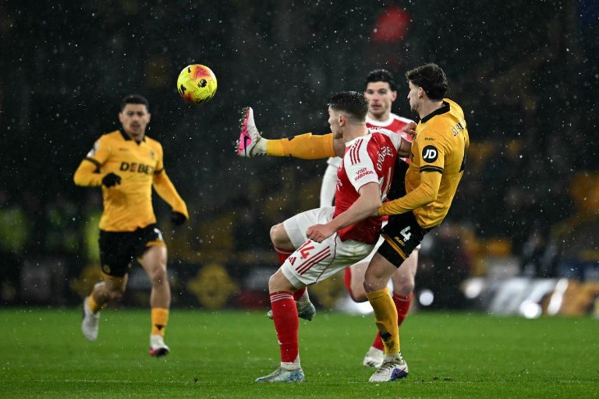 Wolverhampton Wanderers' Uruguayan defender #04 Santiago Bueno battles for the ball with Arsenal's Swedish striker #14 Viktor Gyokeres during the English Premier League football match between Wolverhampton Wanderers and Arsenal at the Molineux stadium in Wolverhampton, central England on February 18, 2026.  Paul ELLIS / AFP