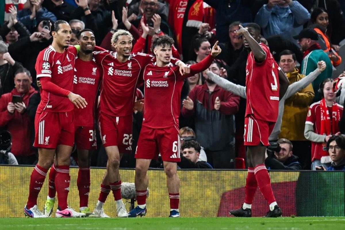Liverpool's Dutch midfielder #38 Ryan Gravenberch (2L) celebrates with teammates after scoring his team's third goal during the UEFA Champions League, round of 16 second leg football match between Liverpool and Galatasaray at Anfield in Liverpool, north-west England on March 18, 2026.  Paul ELLIS / AFP