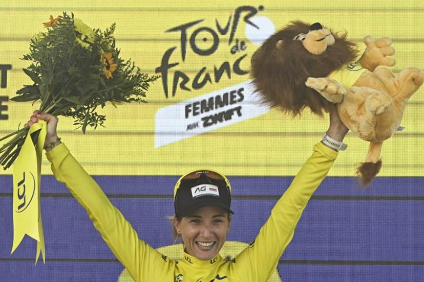 AG Insurance - Soudal Team's Mauritius rider Kimberley Le Court Pienaar celebrates on the podium with the overall leader's yellow jersey after the 5th stage (out of 9) of the fourth edition of the Women's Tour de France cycling race, 165.8 km from Chasseneuil-du-Poitou to Gueret, in Gueret, central France on July 30, 2025.  JULIEN DE ROSA / AFP