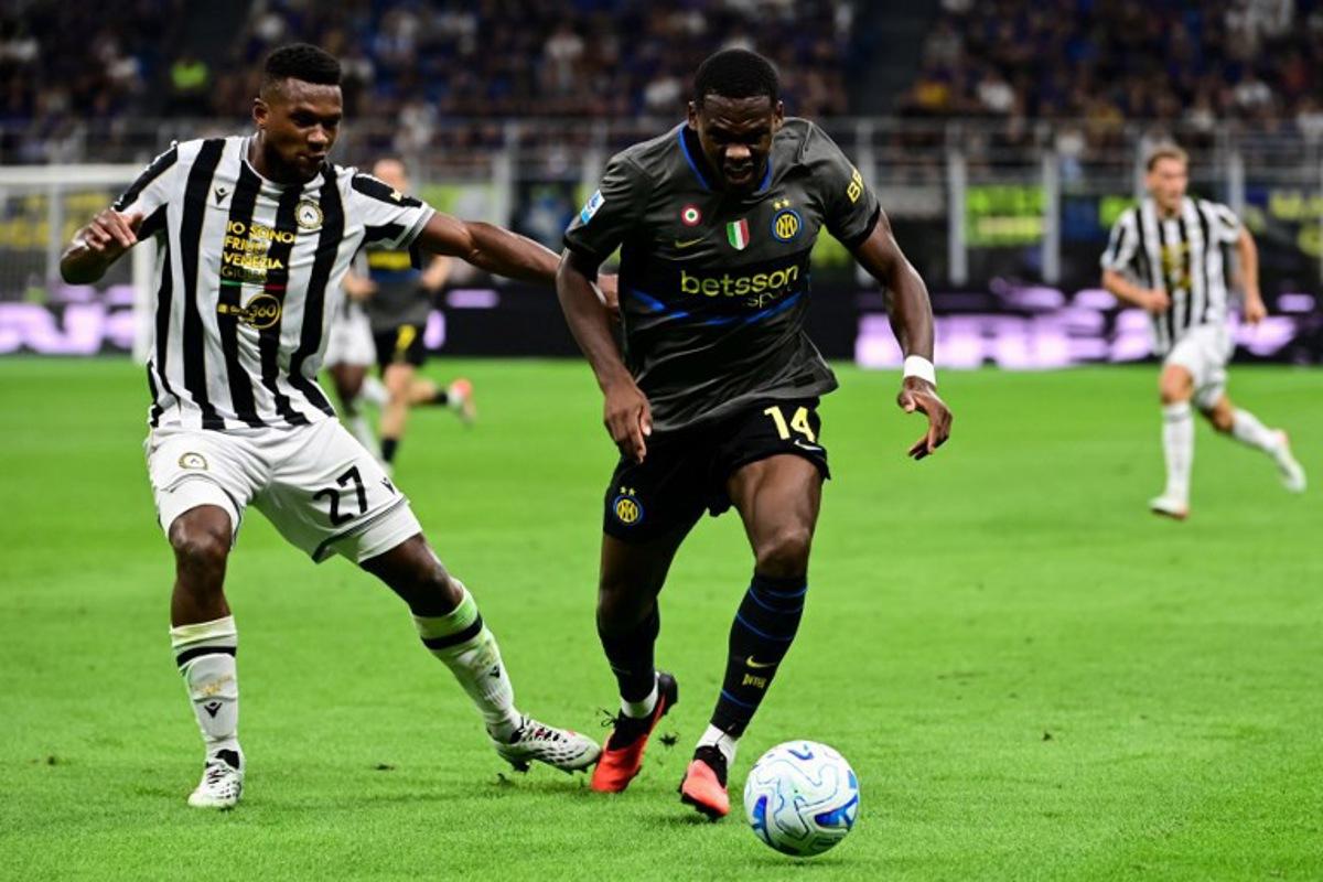 Udinese's Belgian defender #27 Christian Kabasele fights for the ball with Inter Milan's French forward #14 Ange-Yoan Bonny  during the Italian Serie A football match between Inter Milan and Udinese at the San Siro Stadium in Milan, Italy on September 14, 2026.  Piero CRUCIATTI / AFP