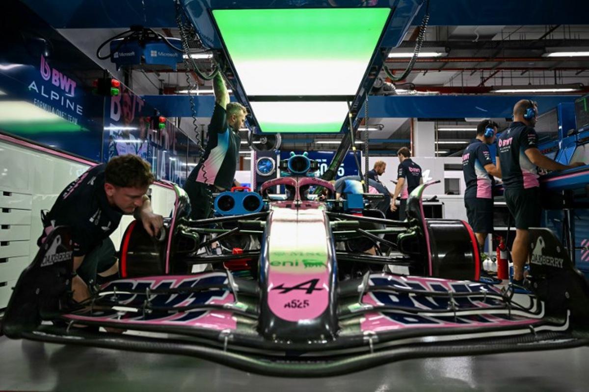 Mechanics work on the car of Alpine's French driver Pierre Gasly in the garage before the second practice session ahead of the Formula One Singapore Grand Prix night race at the Marina Bay Street Circuit in Singapore on October 3, 2025.  MOHD RASFAN / AFP