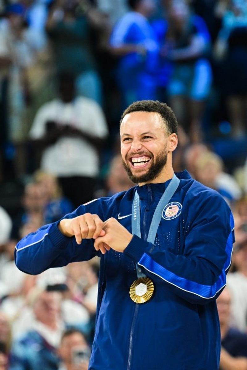 Gold medallist USA's #04 Stephen Curry poses on the podium after the men's Gold Medal basketball match between France and USA during the Paris 2024 Olympic Games at the Bercy  Arena in Paris on August 10, 2024.  Damien MEYER / AFP