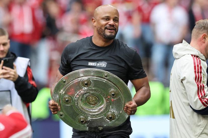 Bayern Munich's Belgian head coach Vincent Kompany walks with the trophy in his hands after a beer shower during celebrations after the German first division Bundesliga football match between FC Bayern Munich and FC Cologne in Munich, southern Germany, on May 16, 2026.  Alexandra BEIER / AFP