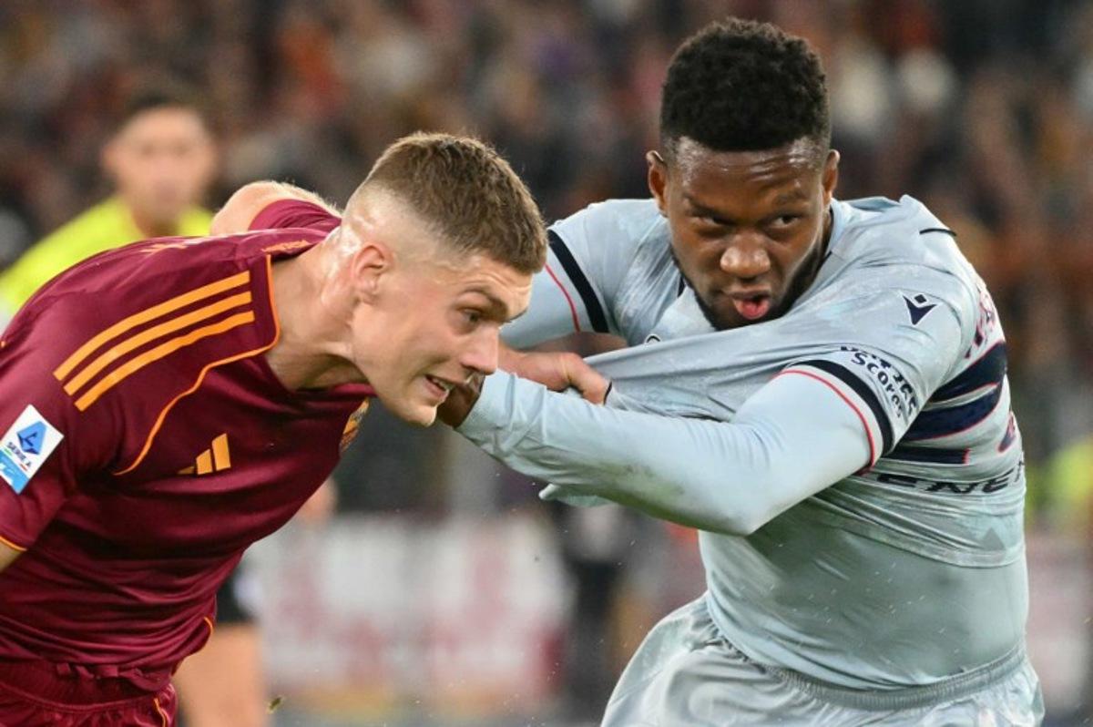 Roma's Ukrainian forward #09 Artem Dovbyk fights for the ball with Udinese's Belgian defender #27 Christian Kabasele during the Italian Serie A football match between AS Roma and Udinese at the Olympic Stadium in Rome on November 9, 2025.  Alberto PIZZOLI / AFP