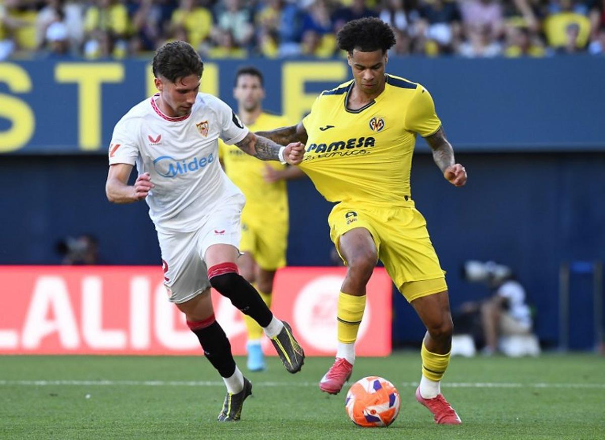 Sevilla's Spanish defender #02 Jose Carmona grasps Villarreal's Canadian midfielder #09 Tajon Buchanan's jersey during the Spanish league football match between Villarreal CF and Sevilla FC at La Ceramica Stadium in Vila-real, on May 25, 2025.  Jose Jordan / AFP