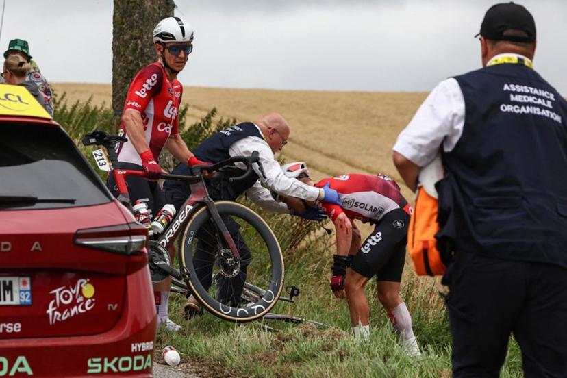 Lotto team's Belgian rider Jasper De Buyst (L) looks on as Lotto team's Belgian rider Lennert Van Eetvelt (R) recovers after suffering a crash in the pack of riders, during the 2nd stage of the 112th edition of the Tour de France cycling race, 209.1 km between Lauwin-Planque and Boulogne-sur-Mer, Northern France, on July 6, 2025.  Anne-Christine POUJOULAT / AFP