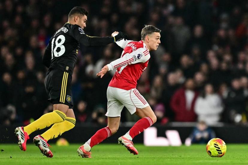 Manchester United's Brazilian midfielder #18 Casemiro (L) tackles Arsenal's Belgian midfielder #19 Leandro Trossard (R) for a free kick during the English Premier League football match between Arsenal and Manchester United at the Emirates Stadium in London on January 25, 2026.   Ben STANSALL / AFP