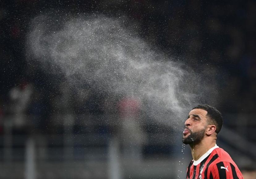 Milan's British defender #32 Kyle Andrew Zac Walker spits water during the Italian Cup semi-final first leg football match between AC Milan and Inter Milan at San Siro stadium in Milan, on April 2, 2025.  Isabella BONOTTO / AFP