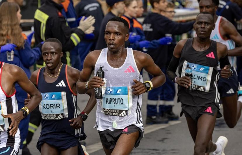 Kenya's Amos Kipruto (C) and Kenya's Ronald Korir (L) pass a water station at the 22km mark as they compete in the men's race of the Berlin Marathon on September 24, 2023 in Berlin, Germany.  Odd ANDERSEN / AFP