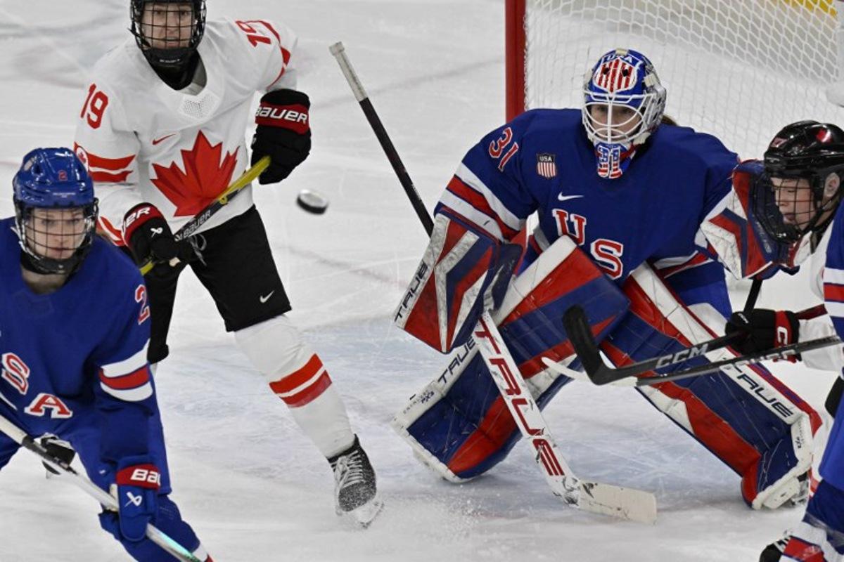 (From L) USA's #02 Lee Stecklein, Canada's #19 Brianne Jenner, and USA's #31 Aerin Frankel vie for the puck during the women's gold medal ice hockey match between USA and Canada at the Milano Santagiulia Ice Hockey Arena during the Milano Cortina 2026 Winter Olympic Games in Milan, on February 19, 2026.  Alexander NEMENOV / AFP