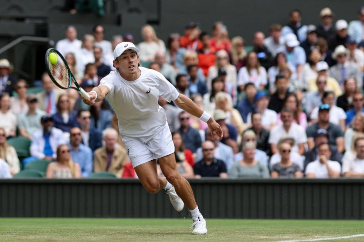 Australia's Alex De Minaur plays a forehand return to Serbia's Novak Djokovic during their men's singles fourth round tennis match on the eighth day of the 2025 Wimbledon Championships at The All England Lawn Tennis and Croquet Club in Wimbledon, southwest London, on July 7, 2025.  Adrian Dennis / AFP
