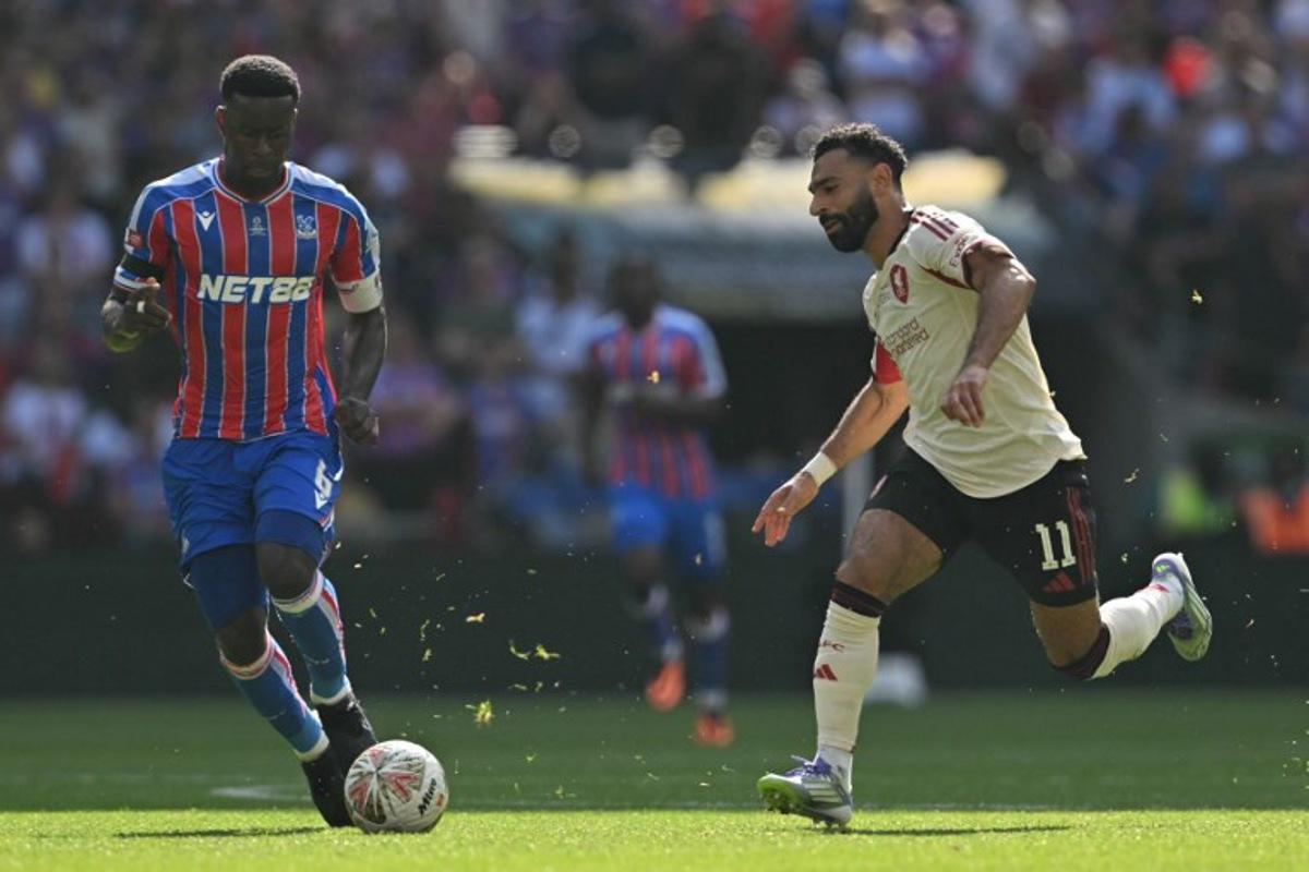 Liverpool's Egyptian striker #11 Mohamed Salah (R) vies with Crystal Palace's English defender #06 Marc Guehi (L) during the English FA Community Shield football match between Crystal Palace and Liverpool at Wembley Stadium, in London on August 10, 2025.  Glyn KIRK / AFP