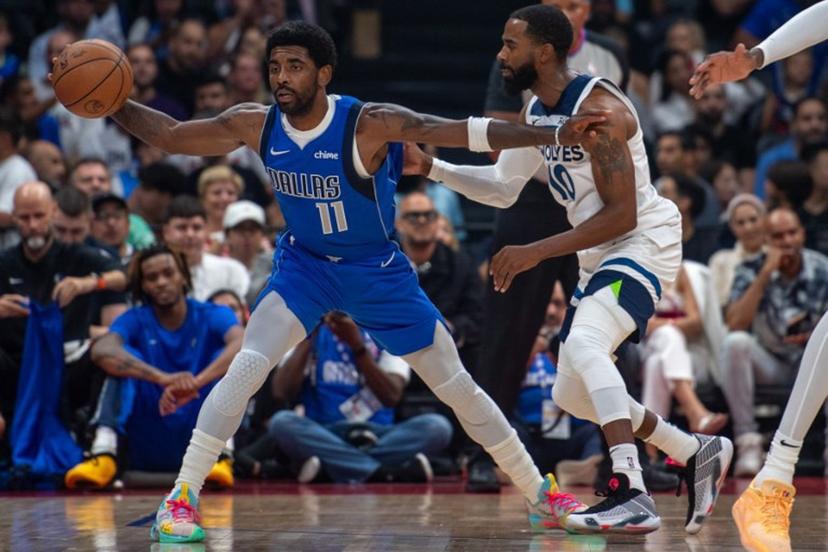 Dallas Mavericks' guard Kyrie Irving #11 is guarded by Minnesota Timberwolves' guard Mike Conley #10 during the NBA Preseason game Between the Dallas Mavericks and the Minnesota Timberwolves at the Etihad Arena in Abu Dhabi on October 5, 2023.  Ryan LIM / AFP