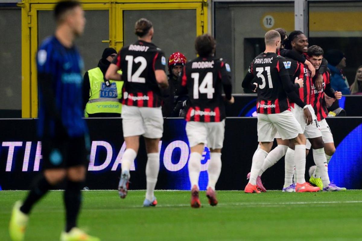 AC Milan's US forward #11 Christian Pulisic (R) celebrates with teammates after scoring his team's first goal during the Italian Serie A football match between Inter Milan and AC Milan at San Siro stadium in Milan, northern Italy, on November 23, 2025.  Marco BERTORELLO / AFP