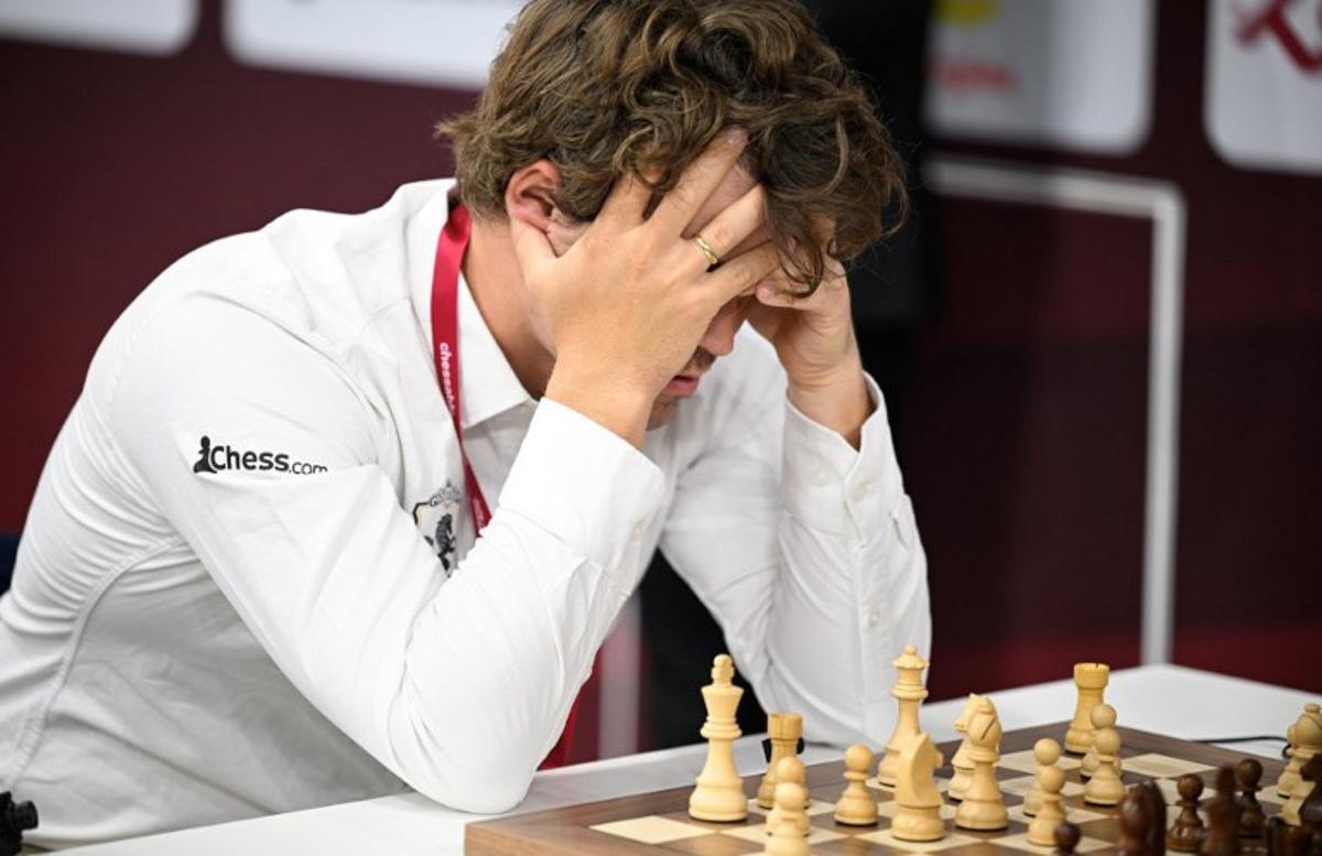 World champion and highest rancked chess player Norway's Magnus Carlsen (L) plays against a Russia opponent during the 10th round of the FIDE World Rapid and Blitz Championships 2025 at the Sports and Events Complex, at Qatar University in Doha on December 28, 2025.  Mahmud HAMS / AFP