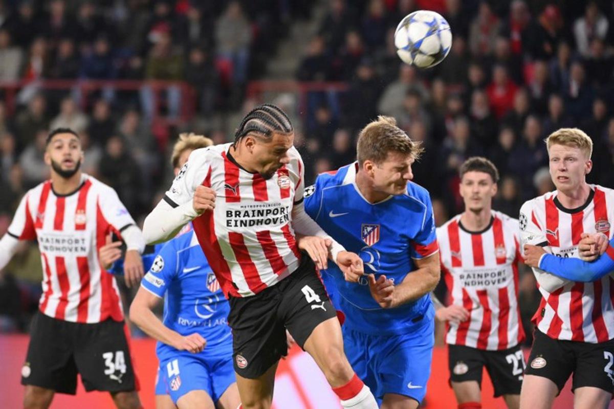 PSV Eindhoven's Dutch defender #04 Armando Obispo heads the ball during the UEFA Champions League, league phase day 6, football match between PSV Eindhoven (NED) and Atletico Madrid (ESP), at the Philips Stadion, in Eindhoven, south of The Netherlands, on December 9, 2025.  JOHN THYS / AFP