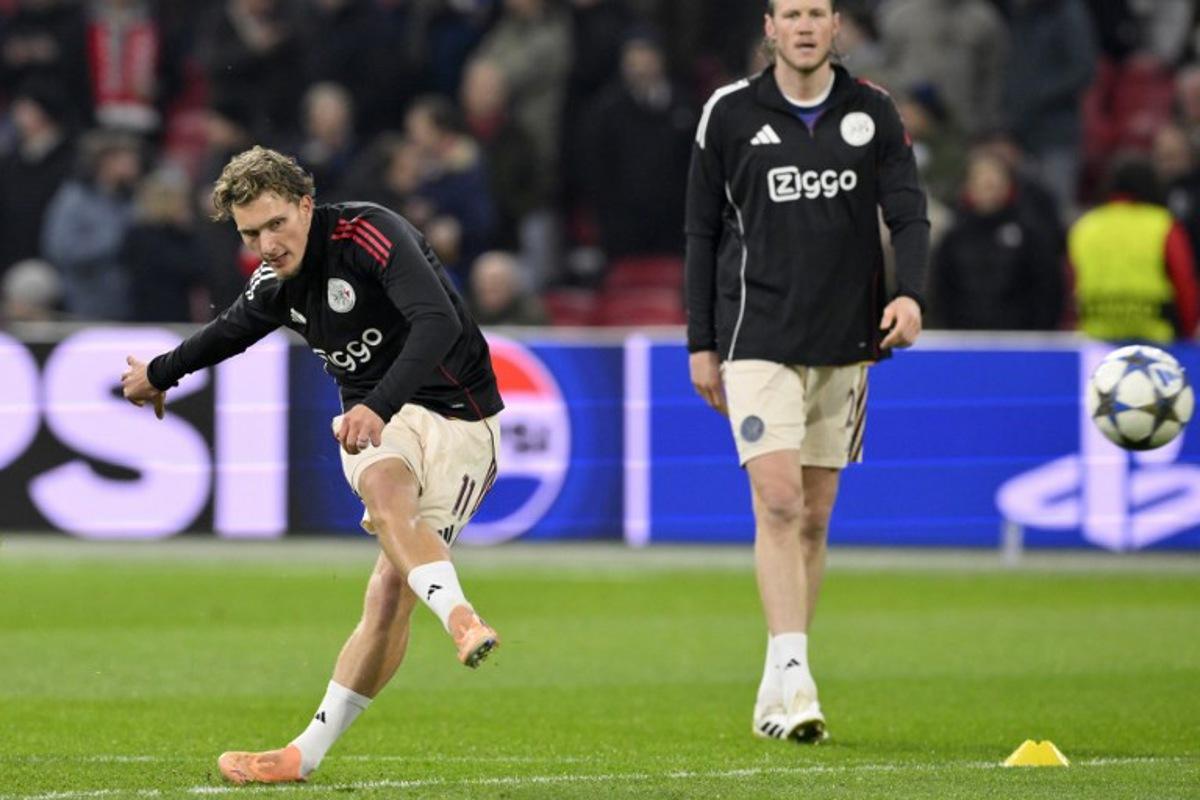 Ajax's Belgian forward #11 Mika Godts (L) warms up prior to the UEFA Champions League, league phase day 5, football match between Ajax and Benfica at the Johan-Cruijff ArenA in Amsterdam on November 25, 2025.  JOHN THYS / AFP
