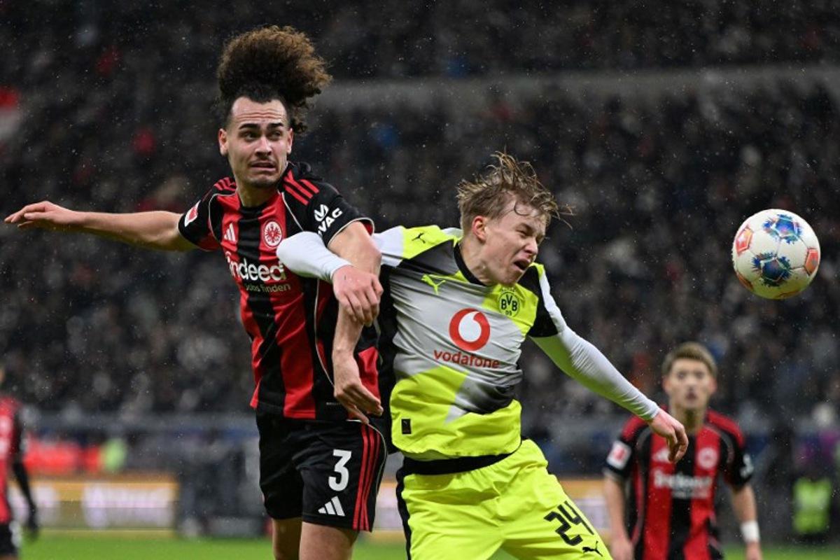 Frankfurt's Belgian defender #03 Arthur Theate (L) and Dortmund's Swedish defender #24 Daniel Svensson vie for the ball during the German first division Bundesliga football match between Eintracht Frankfurt and BVB Borussia Dortmund in Frankfurt am Main, western Germany, on January 9, 2026.  Kirill KUDRYAVTSEV / AFP