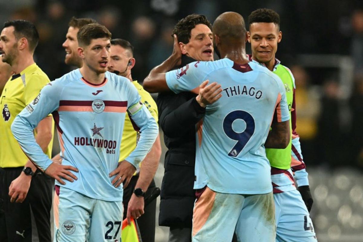 Brentford's Irish head coach Keith Andrews celebrates with his players on the pitch after the English Premier League football match between Newcastle United and Brentford  at St James' Park in Newcastle-upon-Tyne, north east England on February 7, 2026. Brentford won the game 3-2. ANDY BUCHANAN / AFP