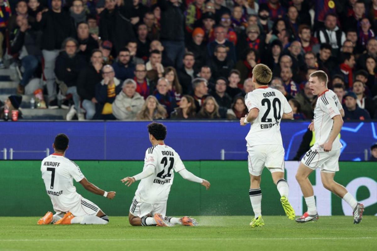 Frankfurt's German forward #07 Ansgar Knauff (L) celebrates scoring his team's first goal during the UEFA Champions League league phase day 6 football match between FC Barcelona and Eintracht Frankfurt at Camp Nou Stadium in Barcelona on December 9, 2025.  Lluis GENE / AFP