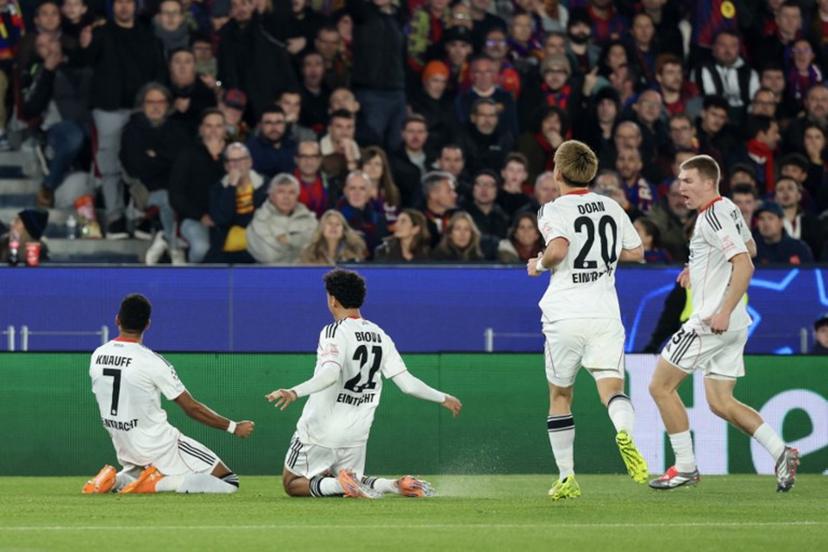 Frankfurt's German forward #07 Ansgar Knauff (L) celebrates scoring his team's first goal during the UEFA Champions League league phase day 6 football match between FC Barcelona and Eintracht Frankfurt at Camp Nou Stadium in Barcelona on December 9, 2025.  Lluis GENE / AFP